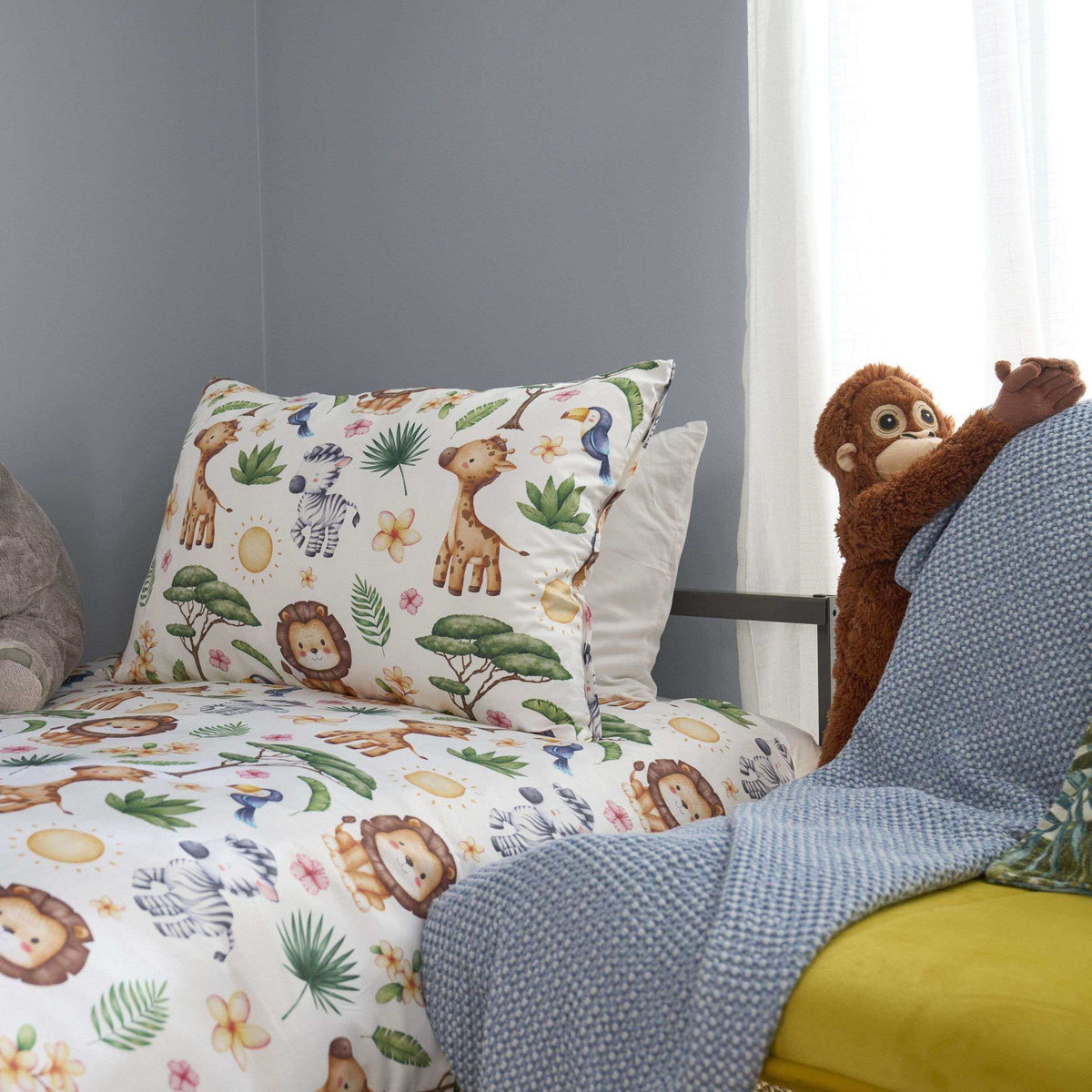 Close up of South African Animals Duvet Cover Set with a toy monkey hanging on a yellow chair