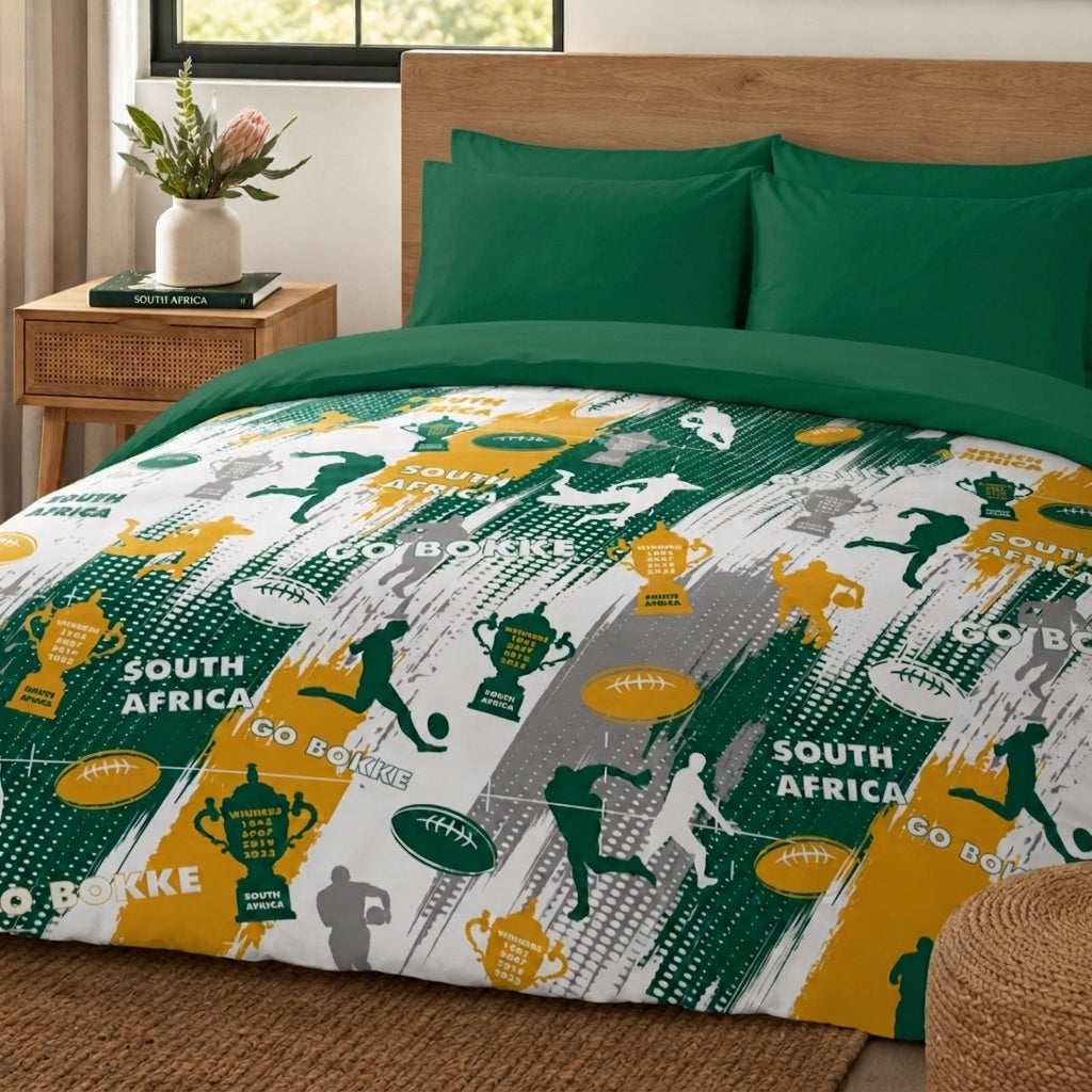 A bed dressed in a South Africa rugby-themed bedding set, featuring a duvet cover and pillowcases with green, yellow, white, and gray sports graphics, silhouettes, and 'SOUTH AFRICA GO BOKKE' text, styled in a bedroom setting.