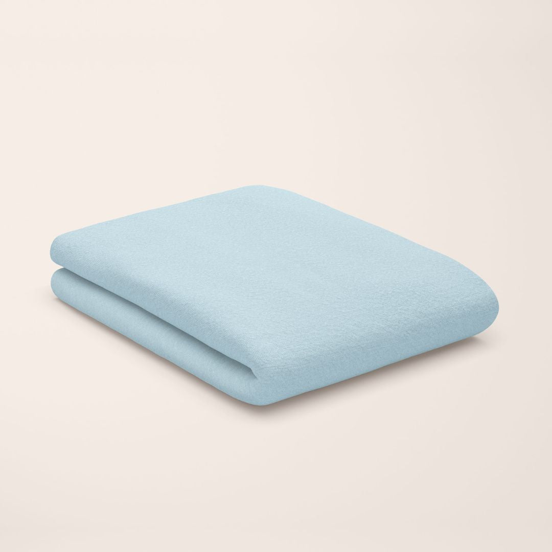Light blue top sheet folded on a beige background
