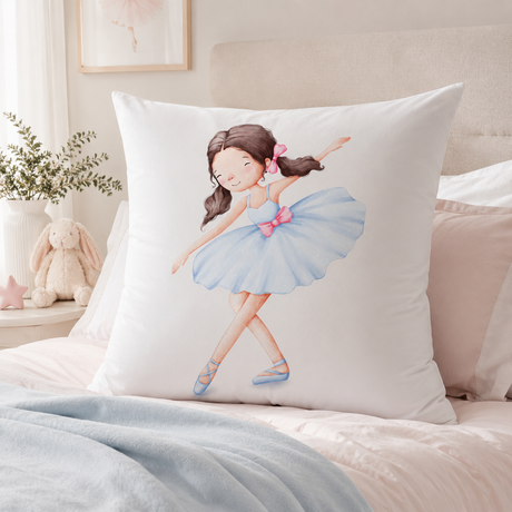 A continental white  pillow featuring a watercolor illustration of a young ballerina in a light blue tutu with pink accents, styled on a bed in a soft, neutral bedroom setting.