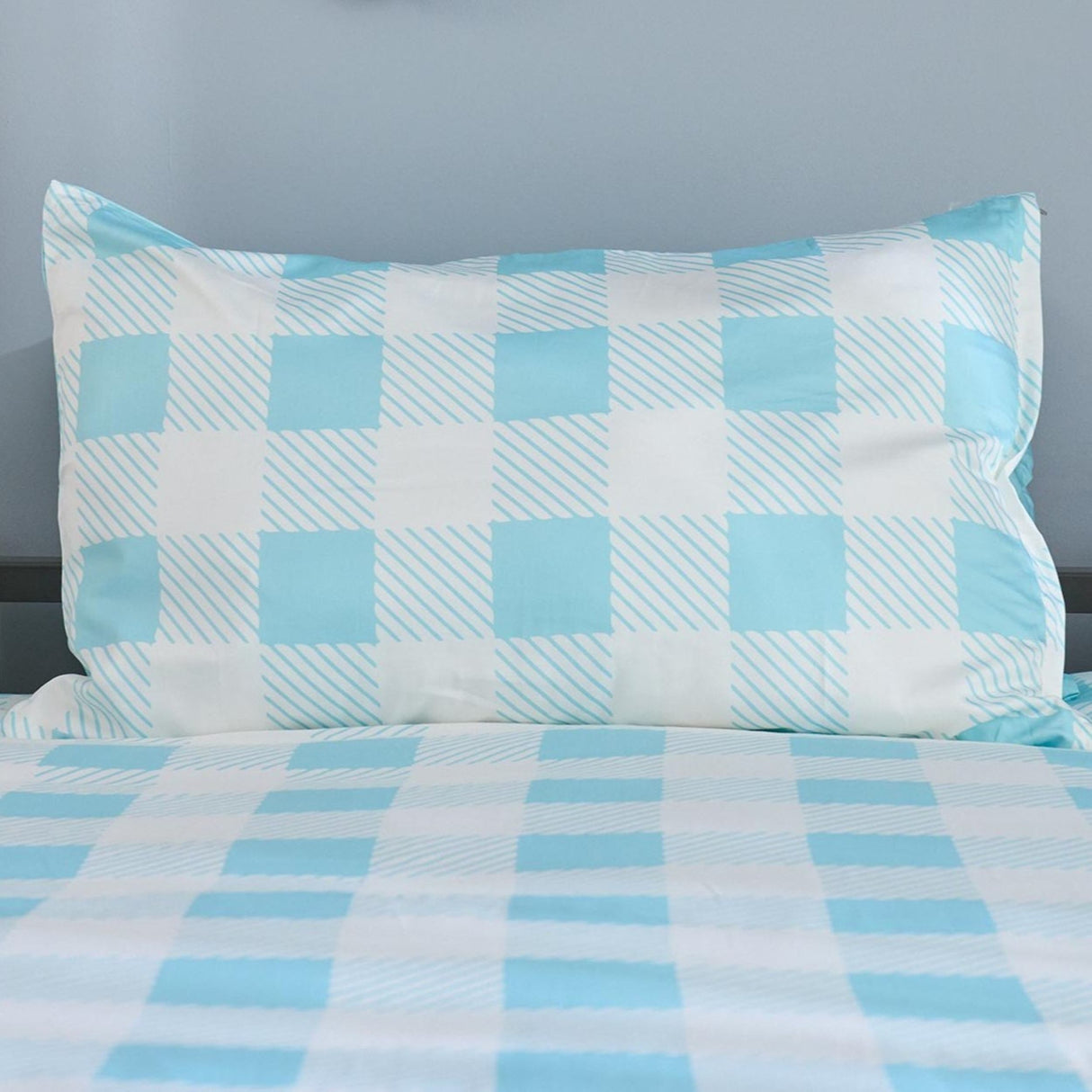 Checkered bedspread with blue and white pattern on a gray background