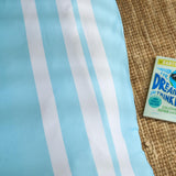 Blue and white striped duvet civer with a box of Dream Thinker on a textured surface