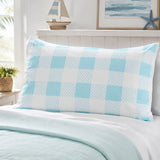 A light blue and white checkered pillow sham on a bed with a matching light blue quilt, styled in a bright bedroom setting.