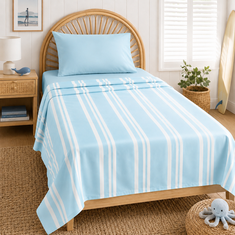 A light blue bedding set with white vertical stripes, including a top sheet and matching pillow, styled on a wooden bed in a bright, nautical-themed bedroom.