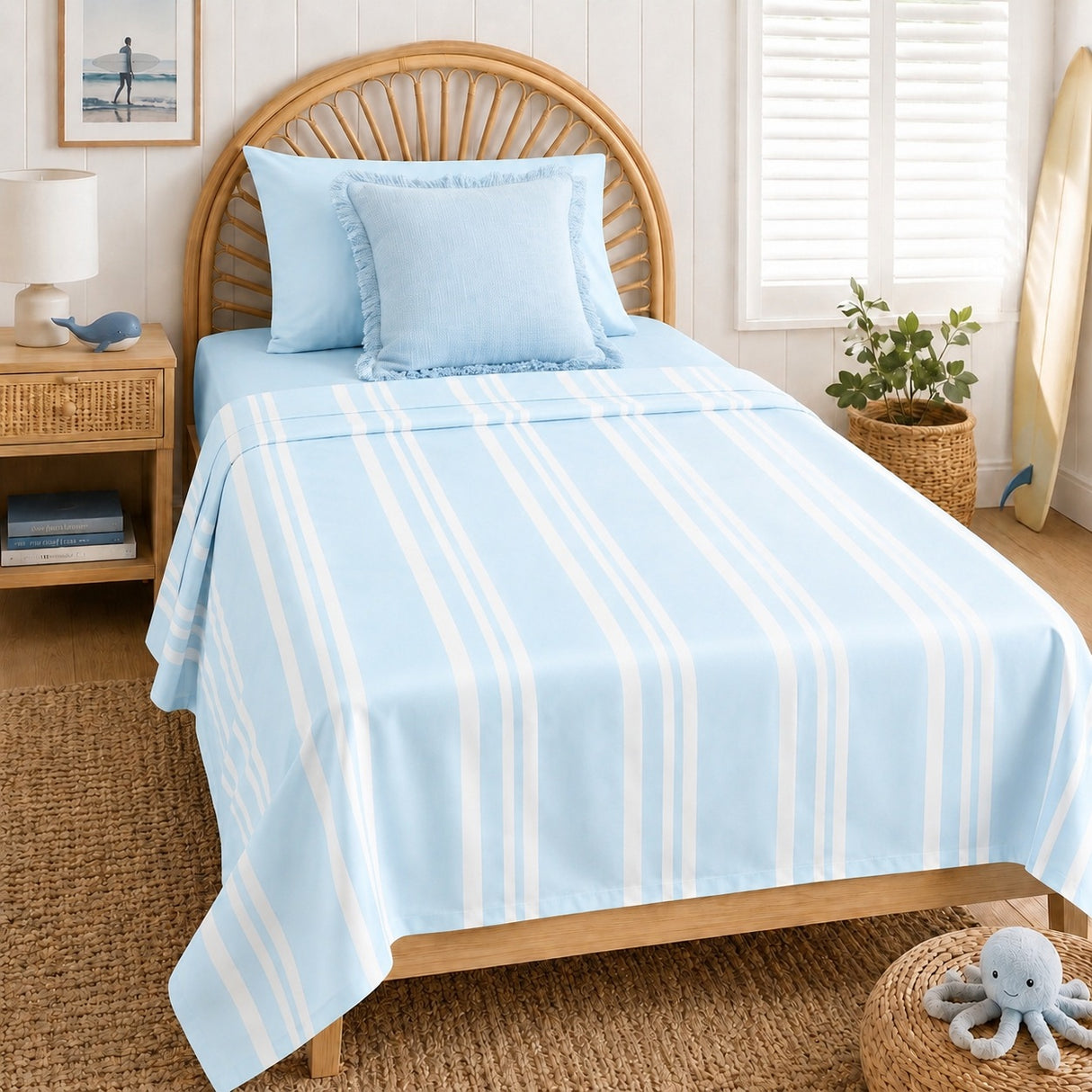 A light blue bedding set with white vertical stripes, including a top sheet and matching pillowcases, styled on a wooden bed in a bright, beach-themed bedroom.