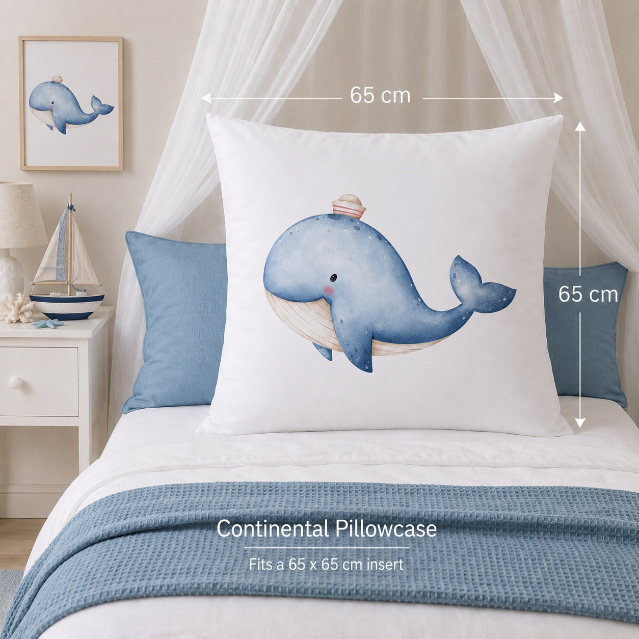A white Continental Pillowcase featuring a watercolor blue whale design, displayed on a bed with dimension arrows indicating a 65 cm by 65 cm size. The scene is styled with a blue pillow, a blue throw blanket, a white bedside table, and a canopy.