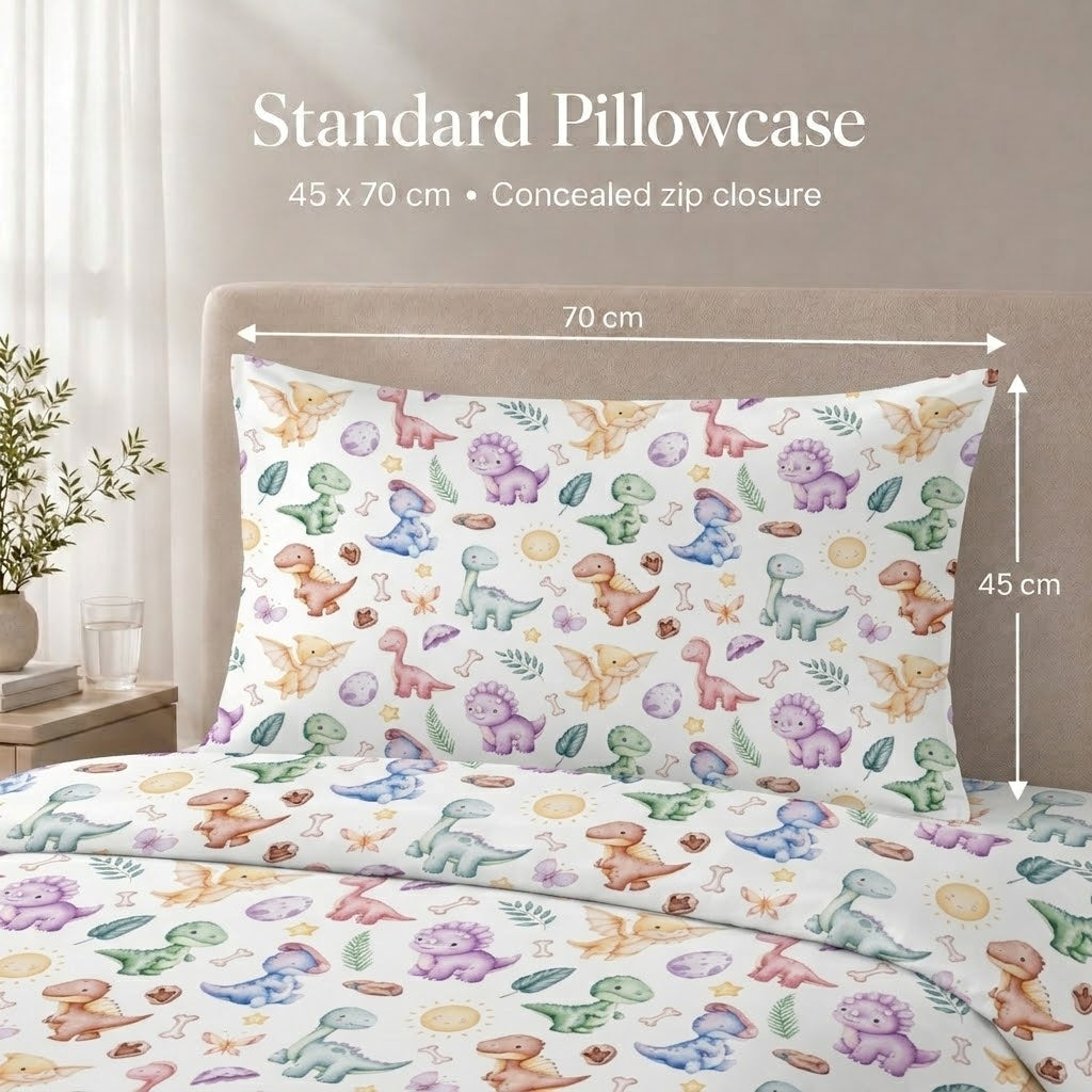 A colorful dinosaur-print kids pillowcase and matching duvet cover displayed on a bed, with overlaid text and dimension arrows showing a standard size of 45 x 70 cm.