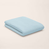 Light blue top sheet folded on a beige background
