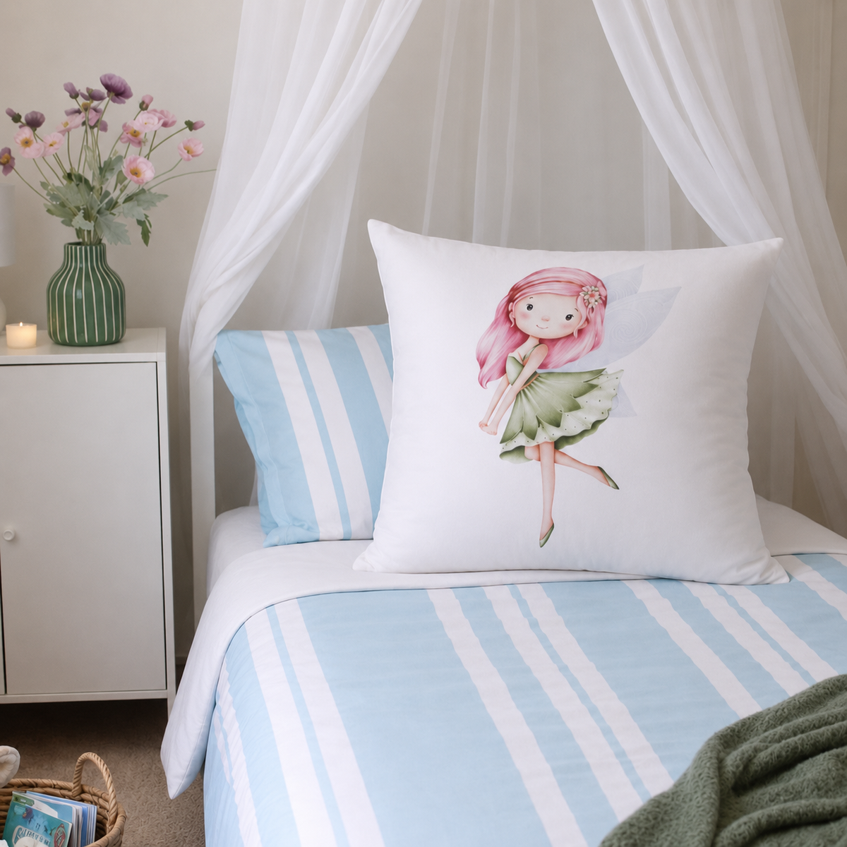 A white decorative continental pillow featuring a watercolor fairy illustration, styled on a bed with light blue and white striped bedding in a softly decorated bedroom setting.