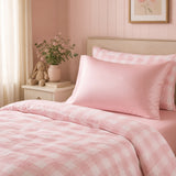 A bed made with abamboo pink and white duvet set with matching pink fitted sheet and pillow.