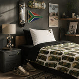 A styled bedroom scene featuring a bed with a white duuvet cover printed with a repeating camouflage-patterned skateboard design. The room has a dark gray wall decorated with a South African flag, a vintage-style Mill Street Park poster, and two skateboards mounted on the wall.
