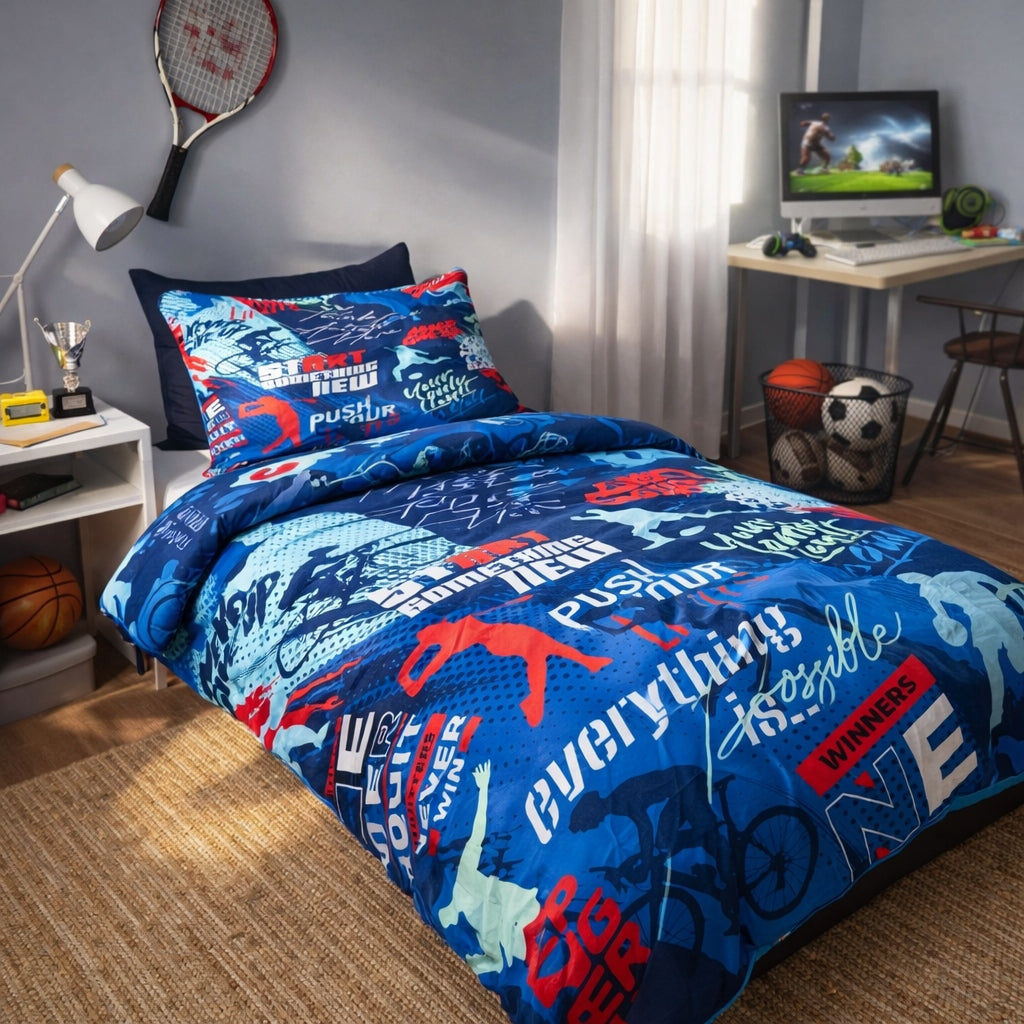Bedroom with blue and red Sports Motivation themed bedding featuring sports-themed graphics, desk with computer, and sports equipment.