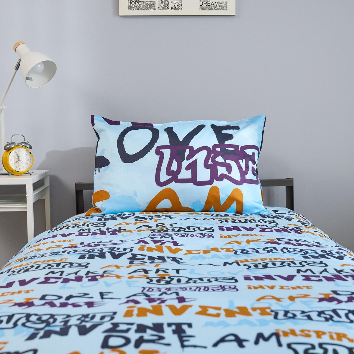 Close up of a light blue duvet cover set with creatively written words on it.