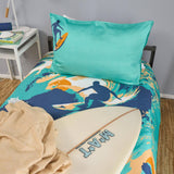 Bedding set with surf design and teal pillow on a bed