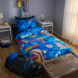 Bedroom with colorful swimming themed bedding featuring swimmers, a backpack on the floor, and a window with curtains.