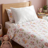 A twin bed dressed in a white fitted sheet set with a fairy themed duvet kids duvet cover and matching pillowcase featuring a pastel fairy and floral print, styled in a bedroom with a wooden headboard, pink wall, bedside table, plant, doll, and books.